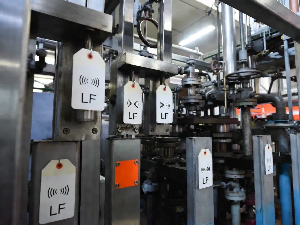 Industrial manufacturing environment demonstrating LF long range RFID tags deployed in metal-heavy stamping lines and fluid-exposed livestock gates where UHF signals fail Industrial manufacturing environment demonstrating LF long range RFID tags deployed in metal-heavy stamping lines and fluid-exposed livestock gates where UHF signals fail